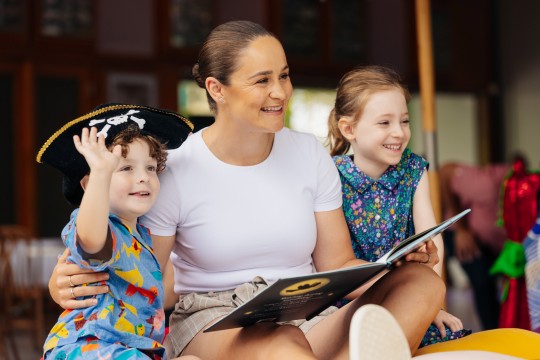Woman reading with 2 children