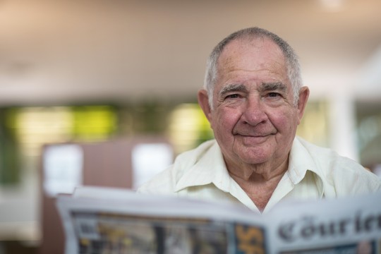 Man reading newspaper in the Caboolture public library.