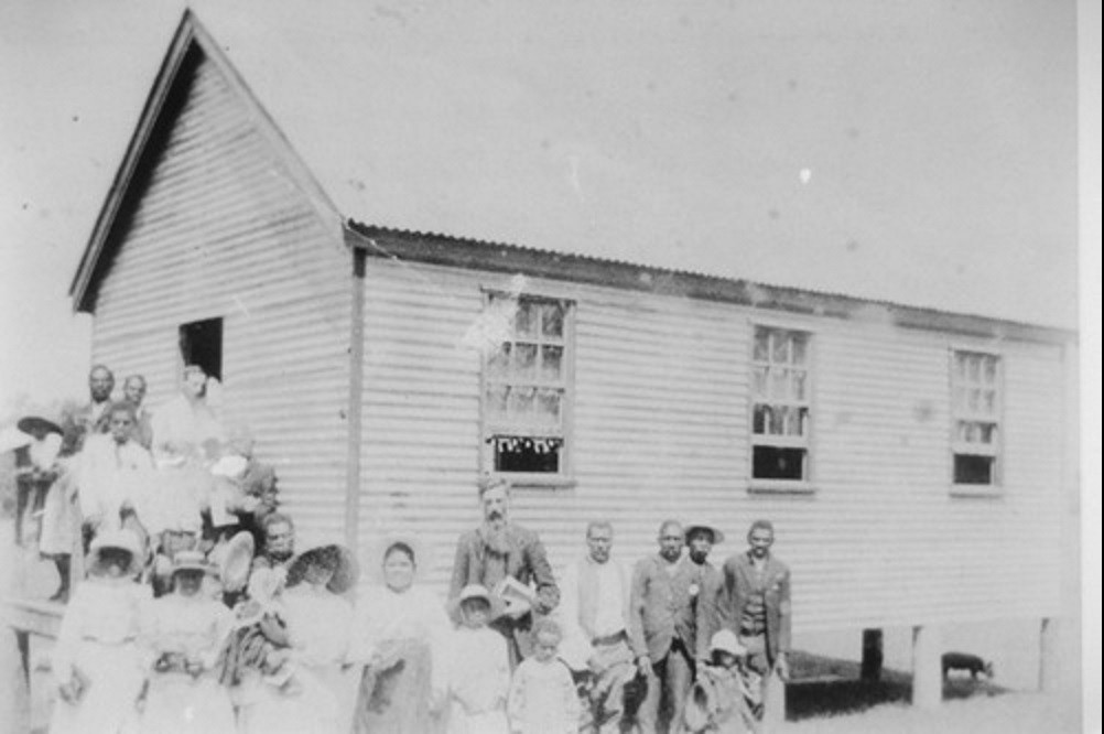 Australian South Sea Islanders standing outside a church in Joskeleigh, Queensland, ca. 1913 Photographer unknown John Oxley Library, State Library of Queensland Image no. 28873-0001-0150
