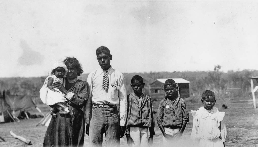 An Aboriginal family with four children standing at a camp site