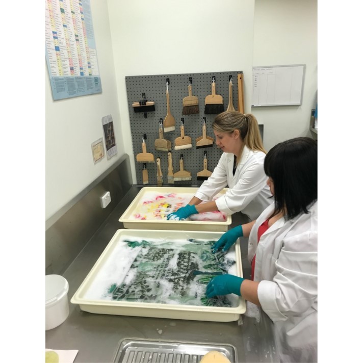 Textiles Conservator Louise McCullagh and Conservation Technician Hannah Nguyen, handwashing jerseys in a pH- neutral detergent bath. 