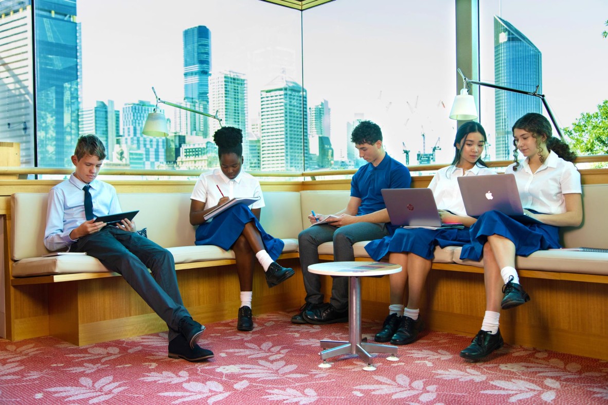 Students stying at State Library. A view of the city is visible through the window behind them.