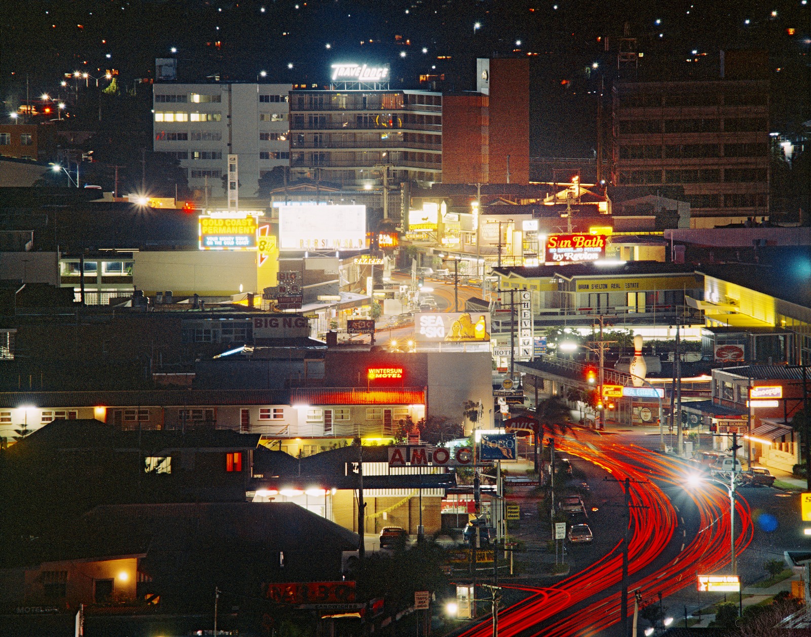Aerial view of a Gold Coast street at nightime with neon lights, 1973