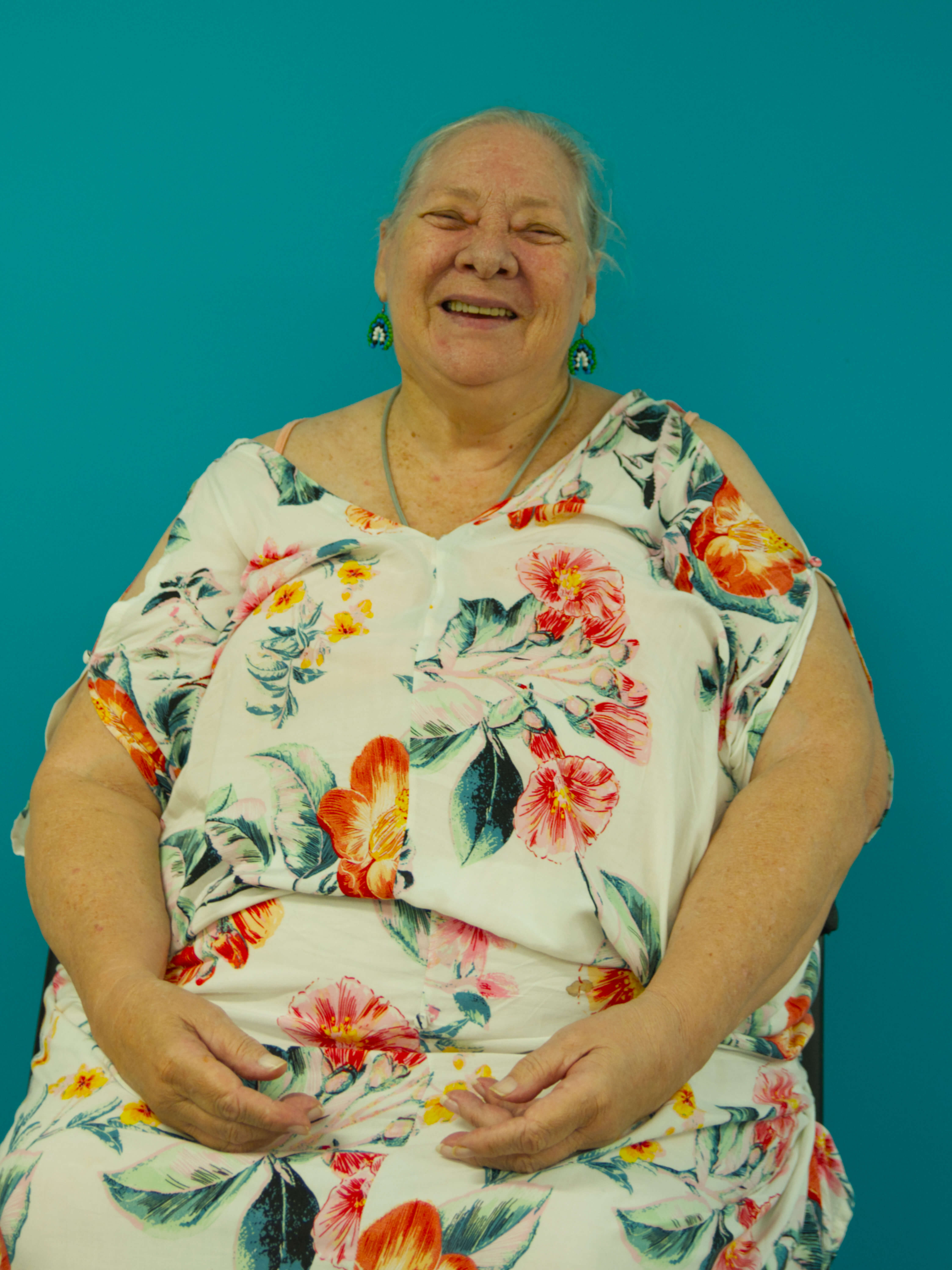 photographic portrait of a Marlene Wilson, a woman with great hair and a white dress with flower patterns looking at the camera