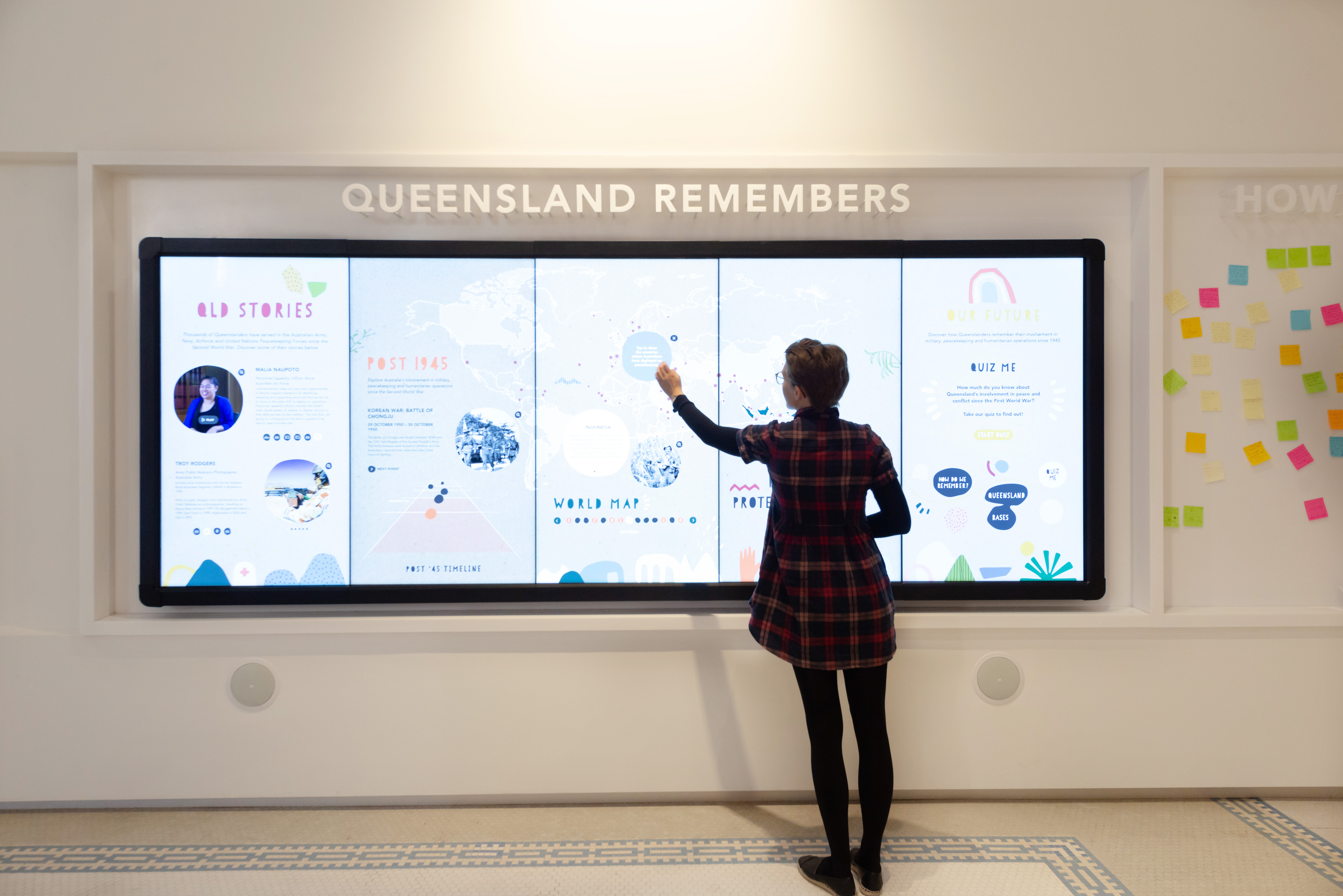 Anzac Square Memorial Galleries - Post World War II Visitor viewing the screens showing content in the Post World War II Gallery space