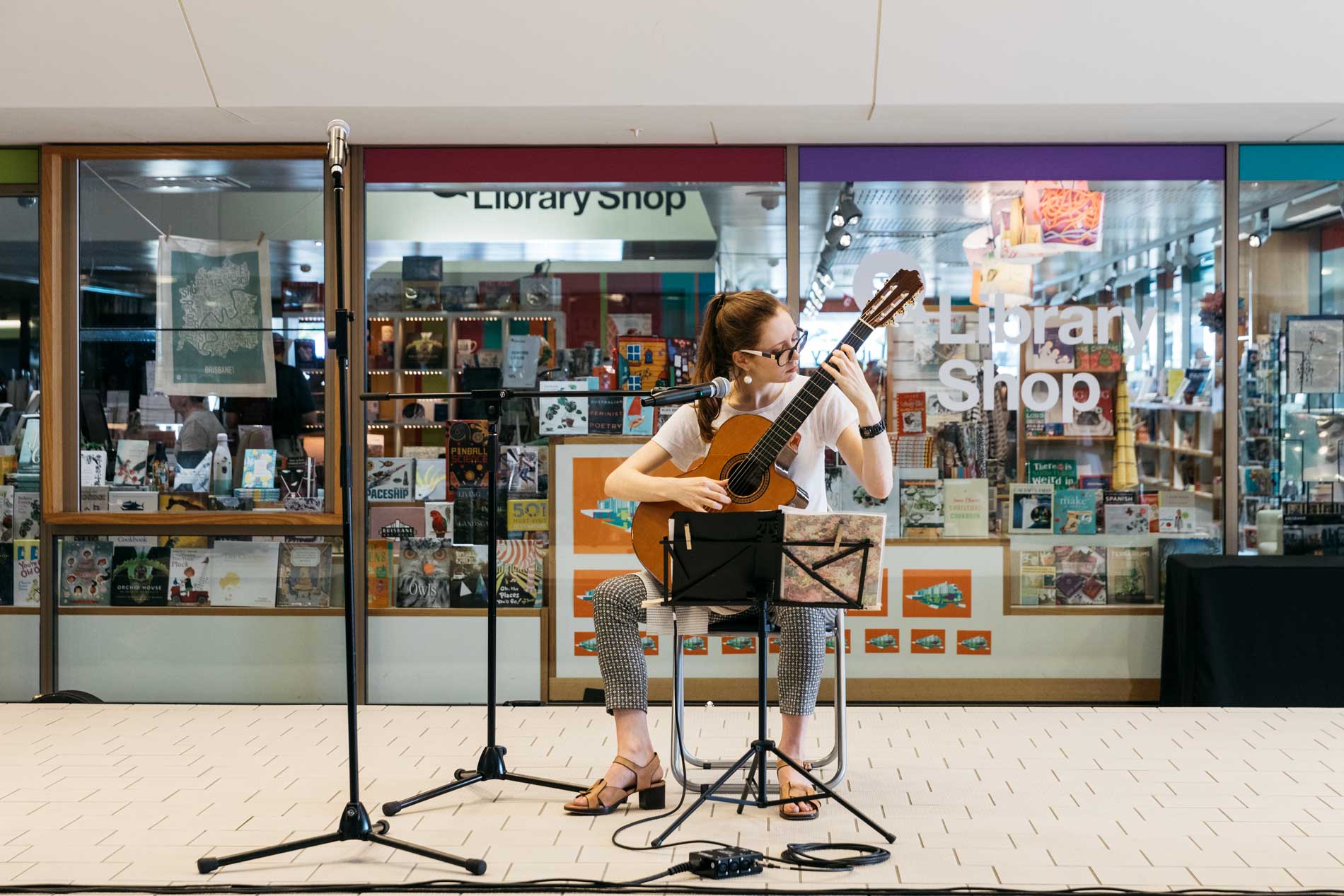A volunteer musician performing outside the State Library Shop