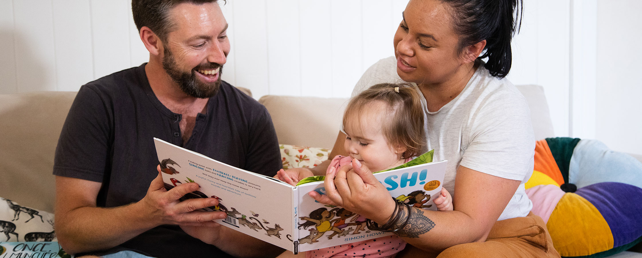 Family reading to small child at home