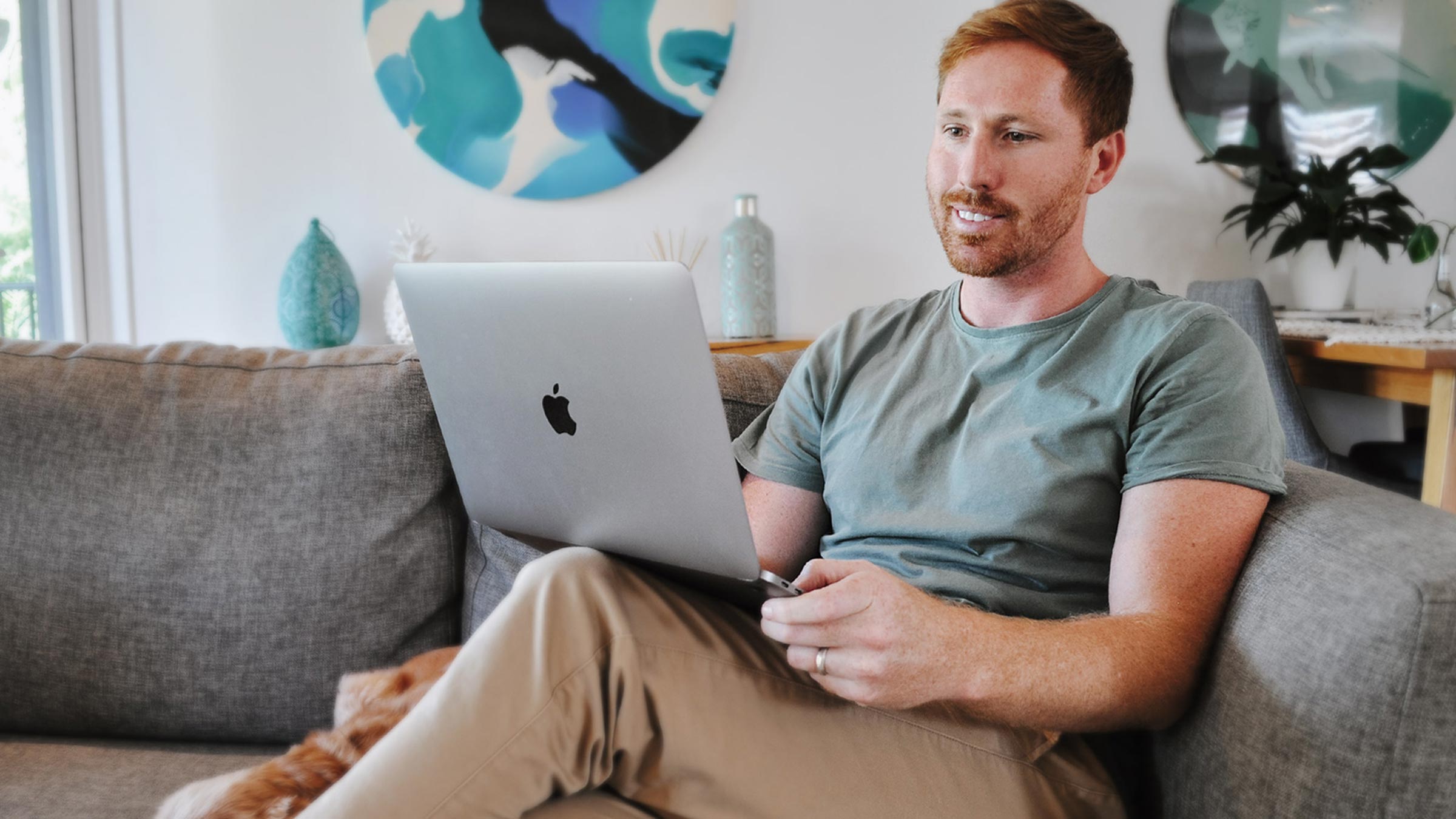 Man sitting on the couch working from home on a laptop