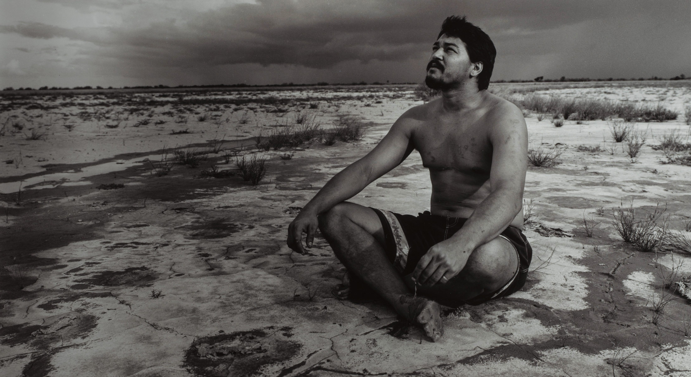 Murrandoo Yanner sitting on the ground looking up to the sky