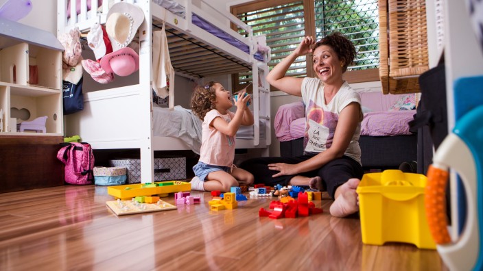 Mother and daughter playing together in childs room
