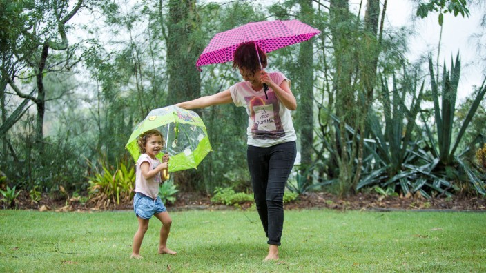 Mother and daughter playing in rain