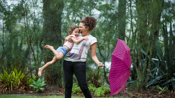 Mother and daughter play with umbrella