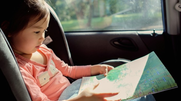 Toddler reading map in car seat