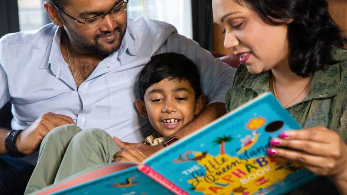 Parents reading book with child Parents reading book with child
