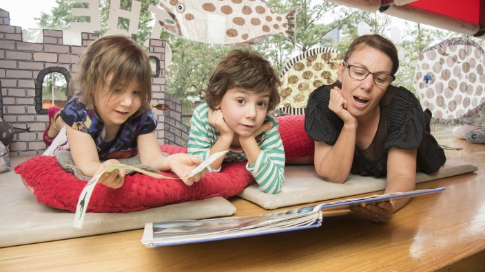 Family reading a picture book in The Corner. Family reading a picture book in The Corner