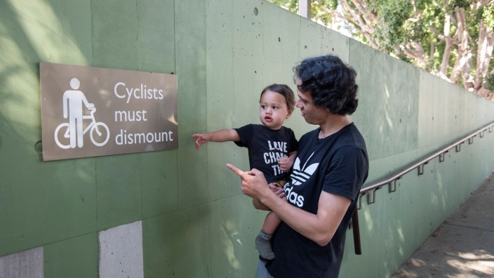 Father and son pointing at bicycle sign