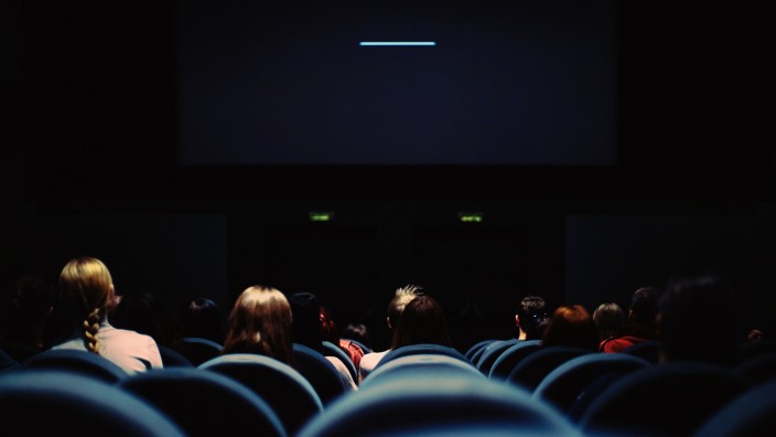 People sitting in seats in front of a screen