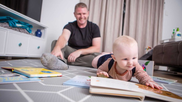 Baby and dad lying on floor with books
