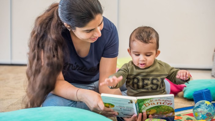 Parent and baby reading together in The Corner
