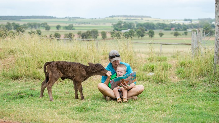 Mother and son reading on farm