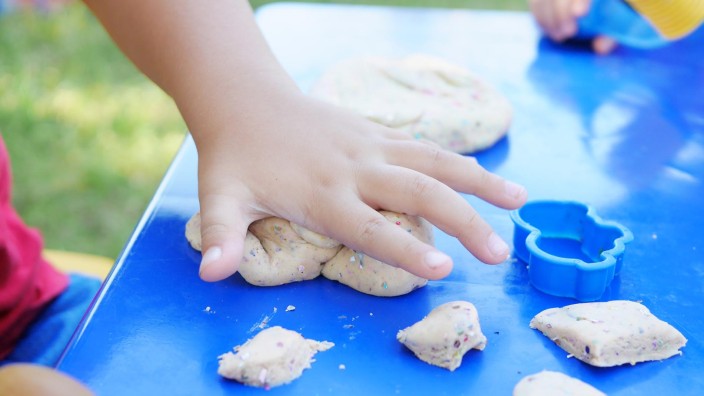 Child playing with play-dough outside