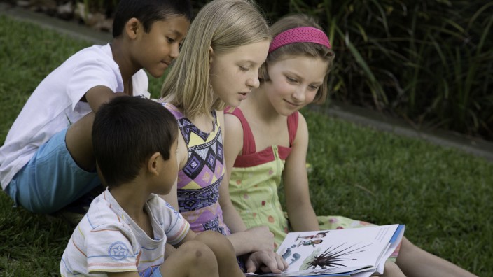Kids reading on grass 2