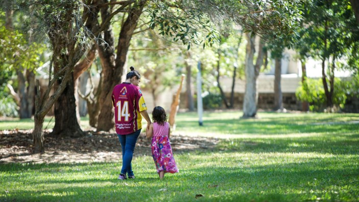 Mother and young child walking in a park