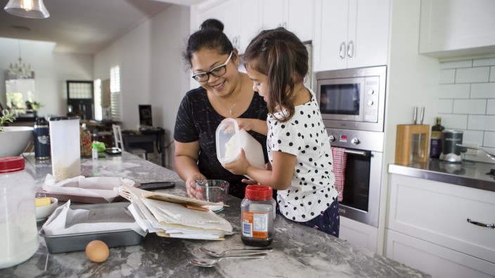 Mother and child in kitchen measuring flour
