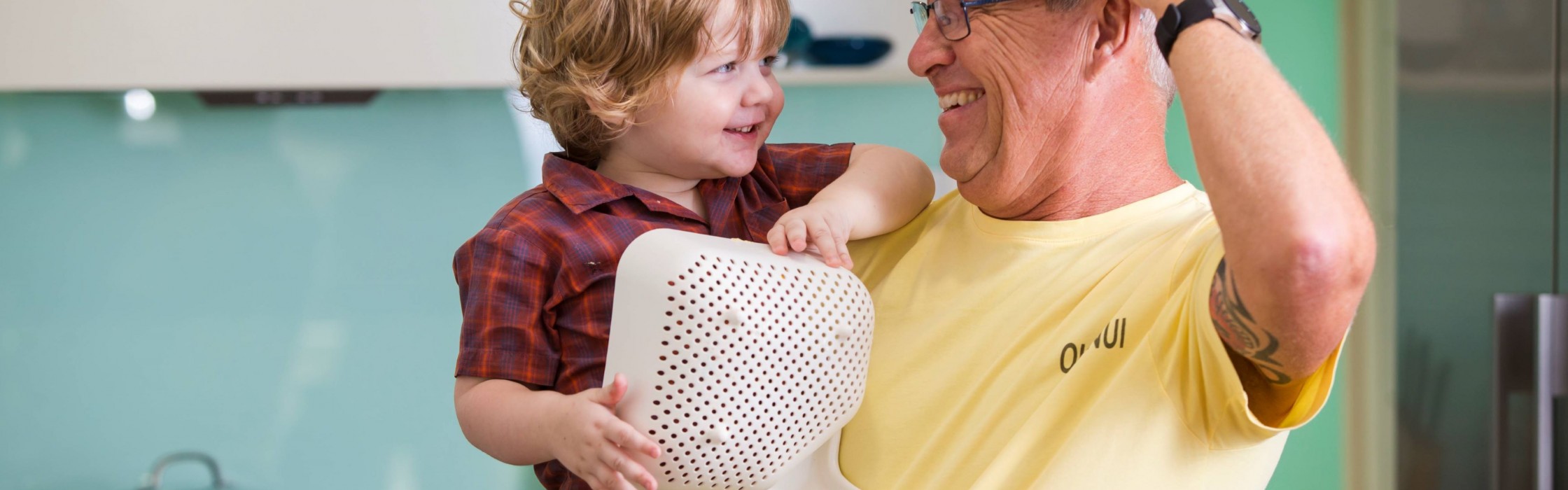 Grandad and toddler playing in kitchen