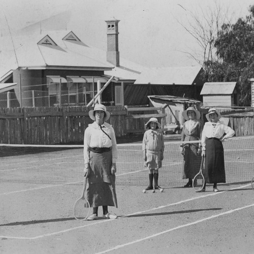 Tennis players standing on a tennis court, ca. 1915