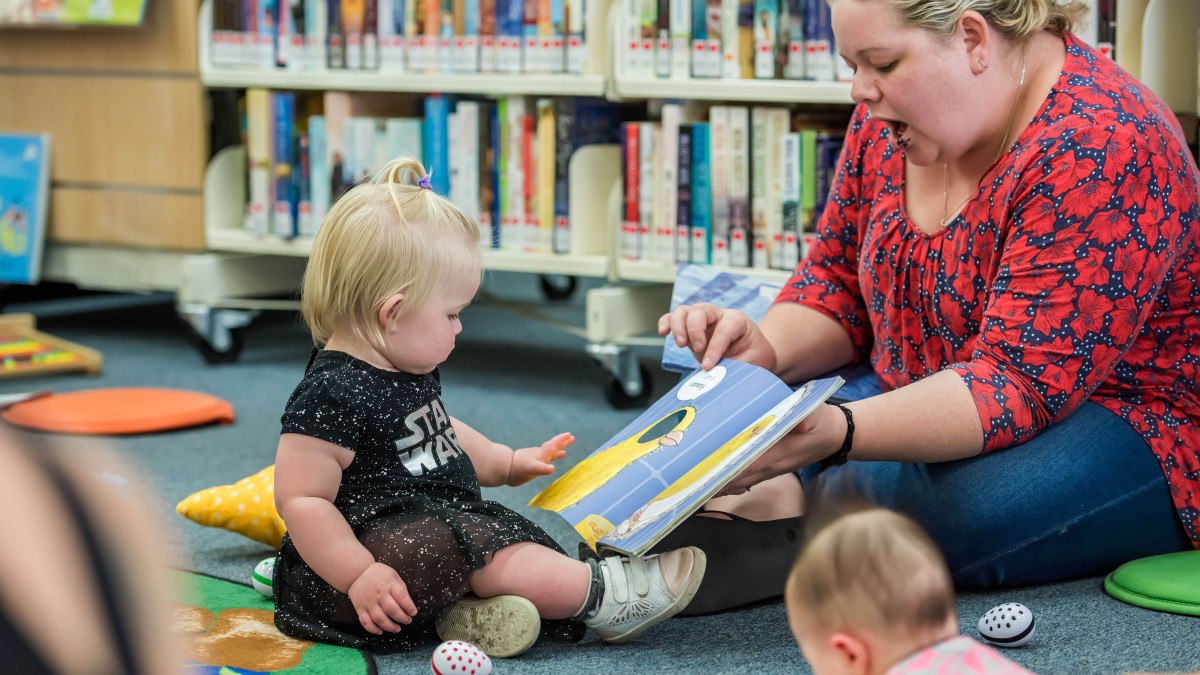 Mother and baby reading a book in Walkston Library Mackay