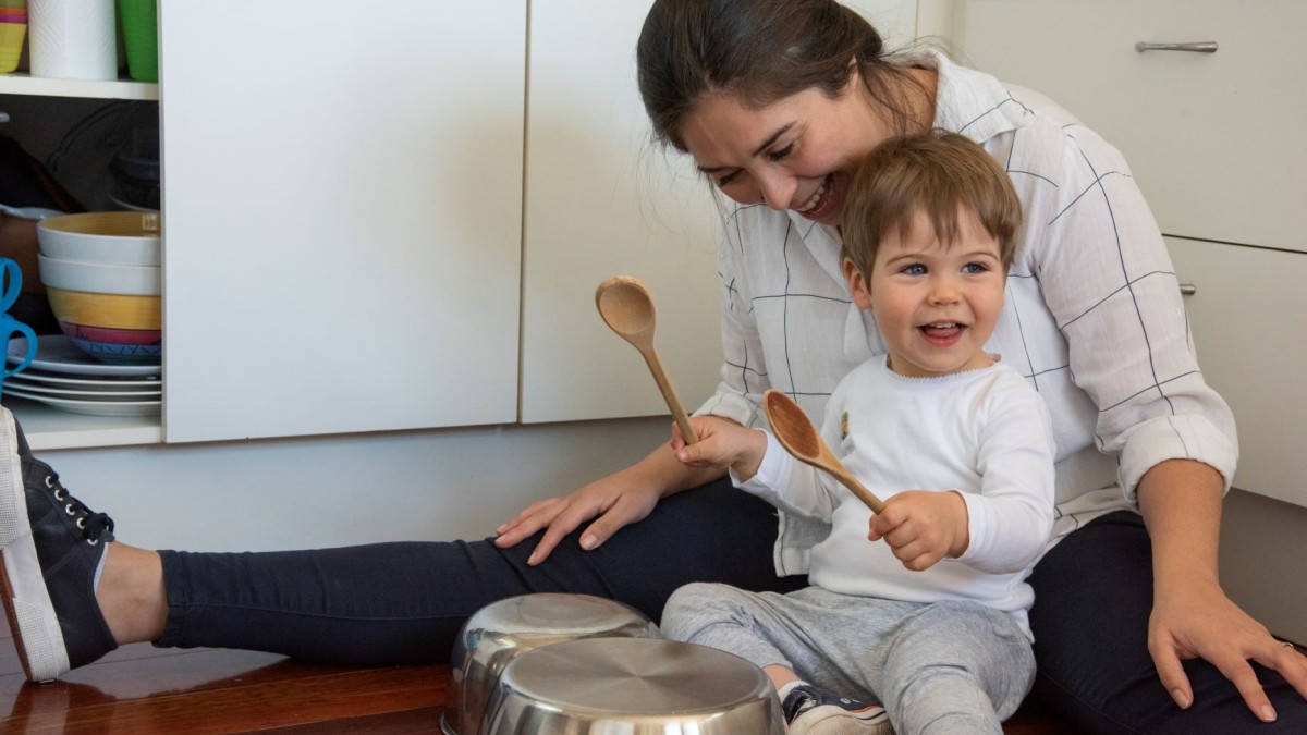 Mother and child playing in the kitchen with pots and pans