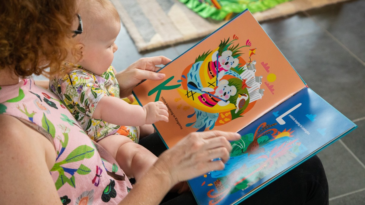Parent and baby sharing the Little Queenslanders Alphabet book