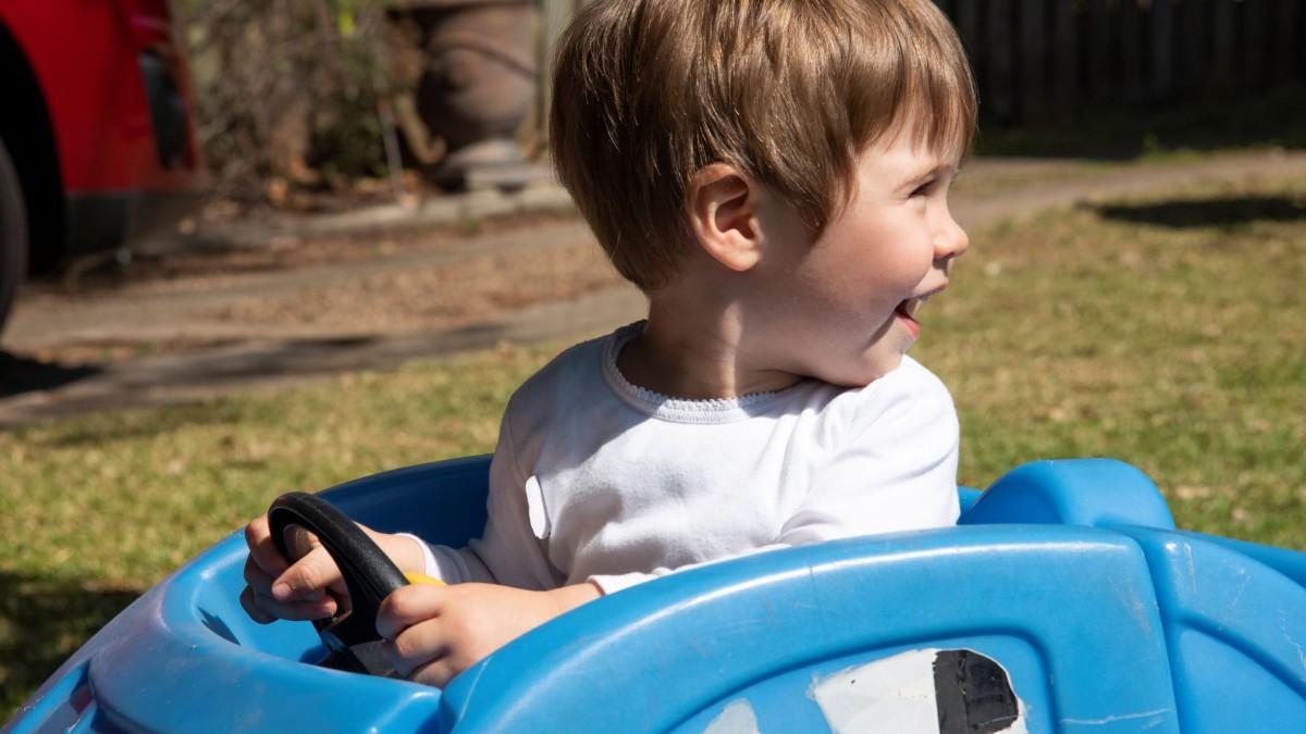 Toddler driving a toy car