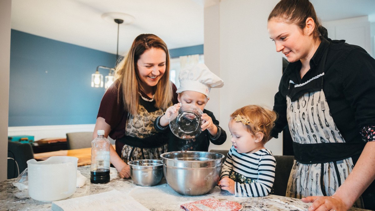 Family with two children cooking together in the kitchen