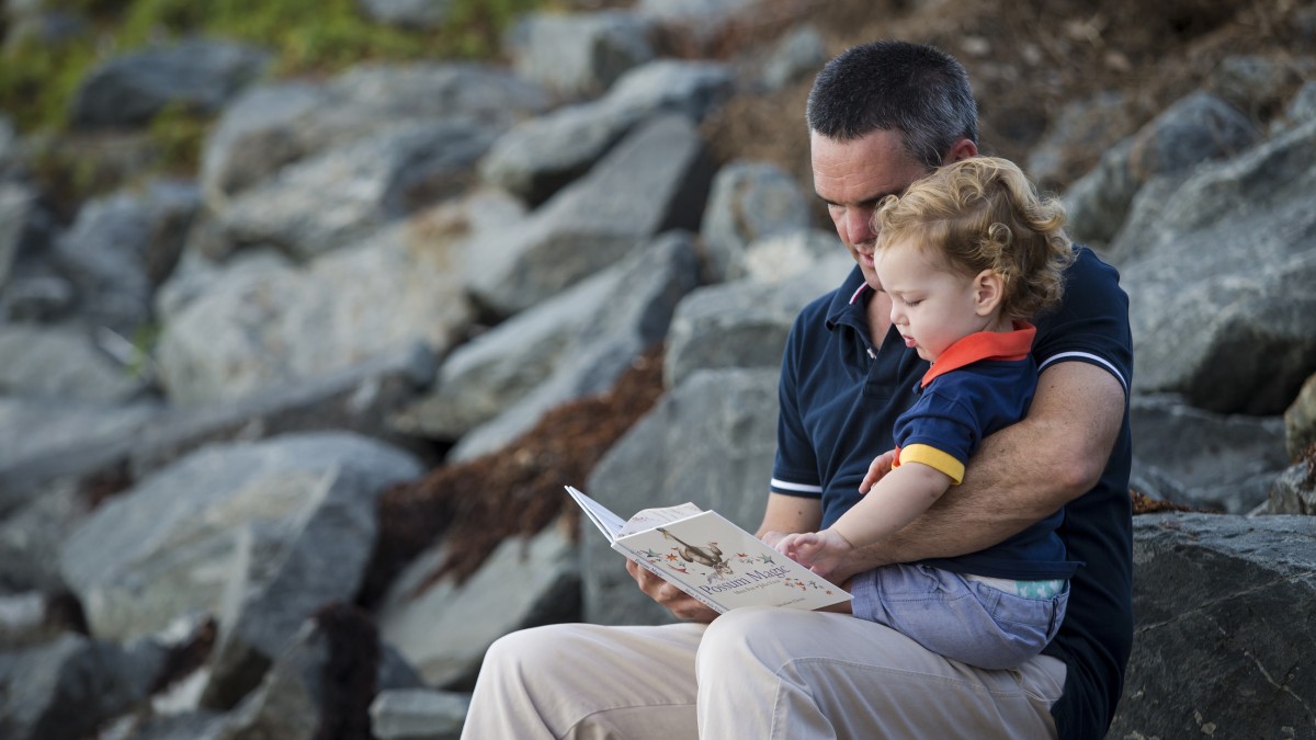 Toddler and father reading a book