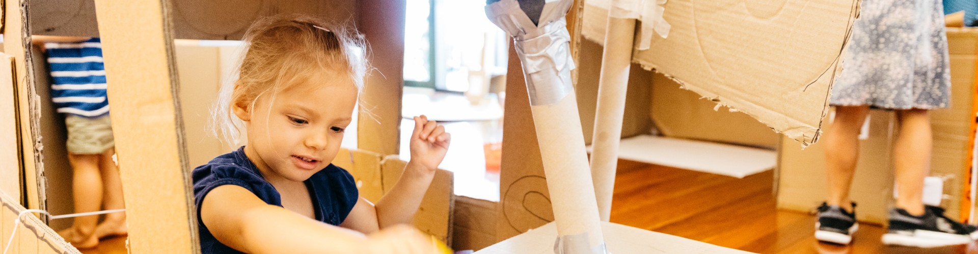 Young girl playing with cardboard