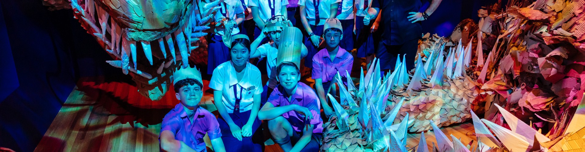High schools students and State Library staff member standing with a large Cardboard Dragon
