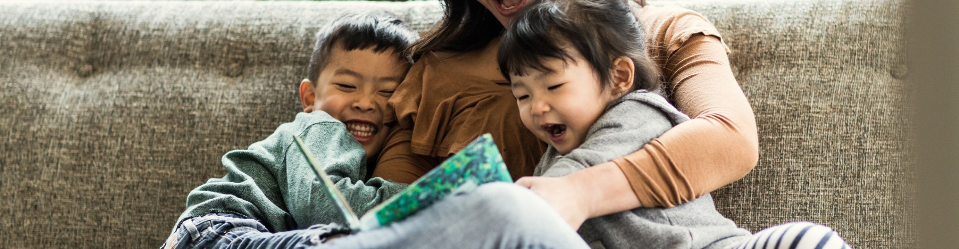Mother with son and daughter reading on a couch