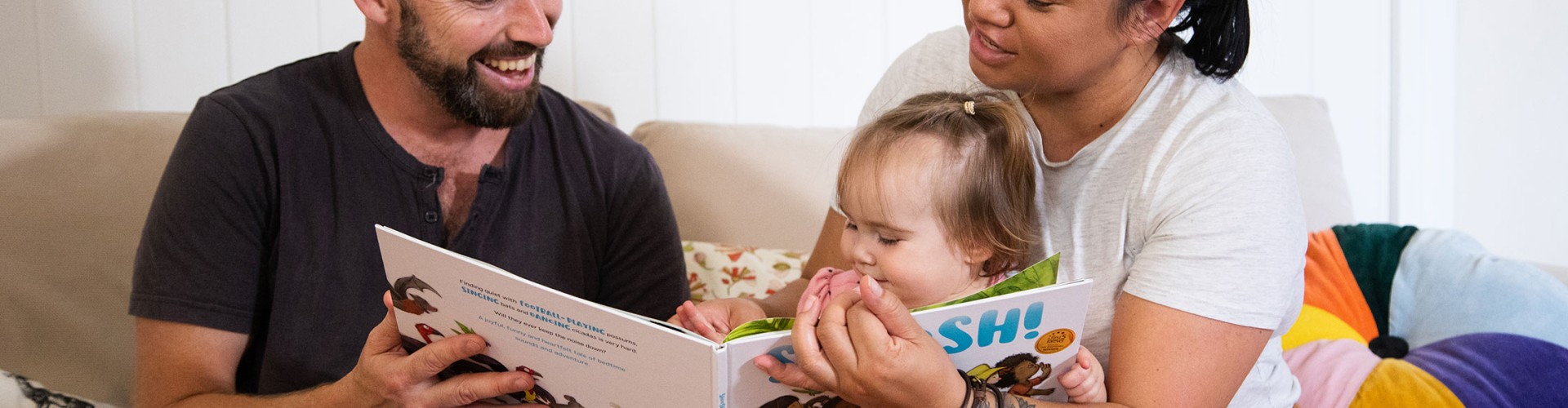 Family reading to small child at home