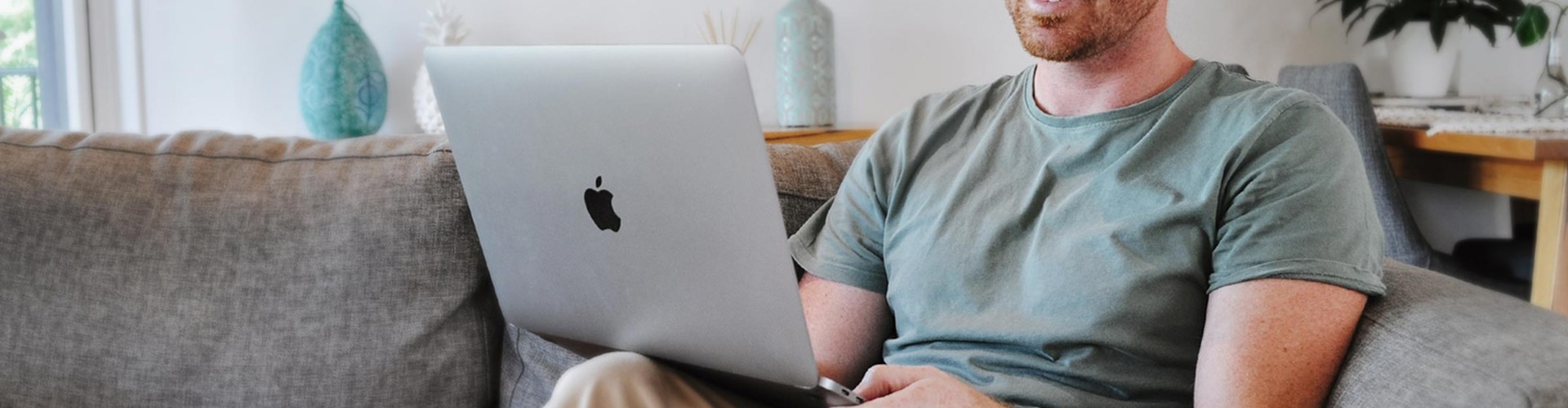 Man sitting on the couch working from home on a laptop