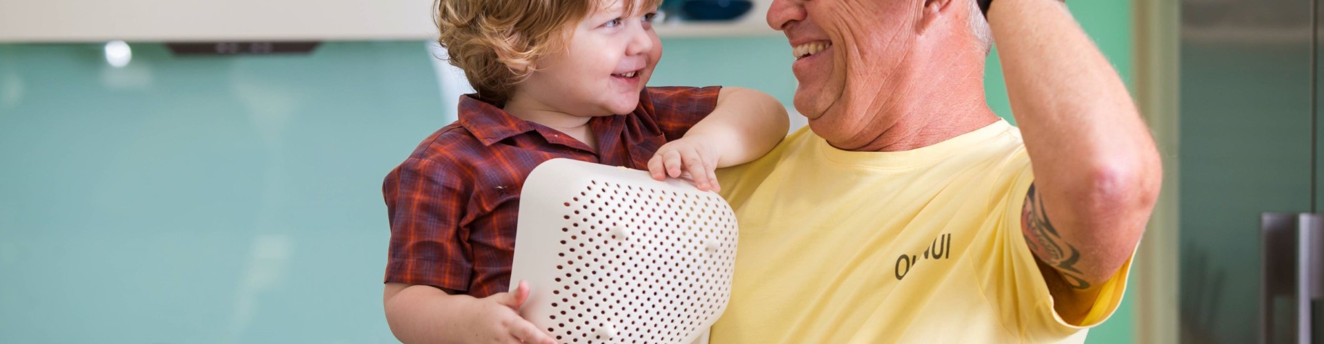 Grandad and toddler playing in kitchen
