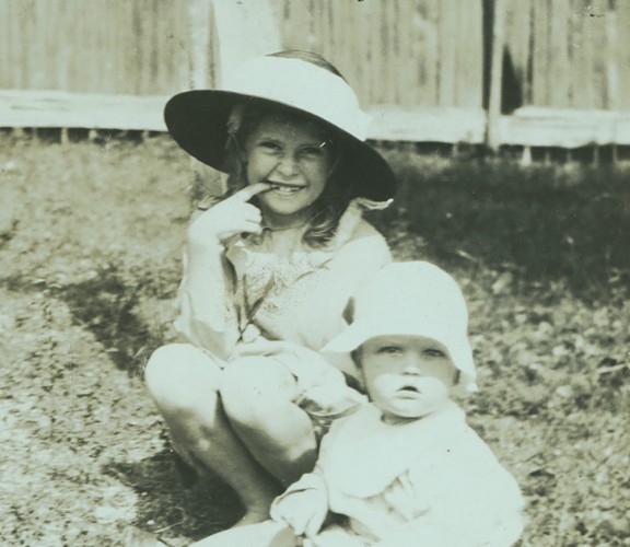 Four children playing in a garden.