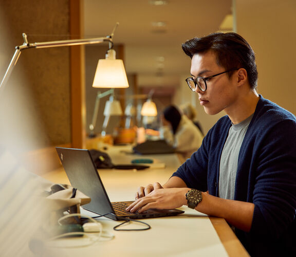 Person working on a laptop in a relaxing space.