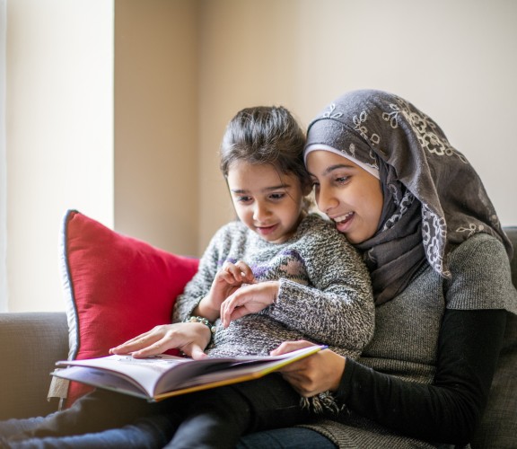 Mother reading with child on her lap