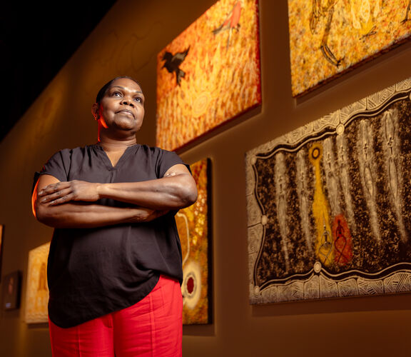Colleen Sam in front of her artwork