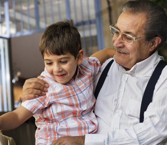 Man with child on his knee, both smiling