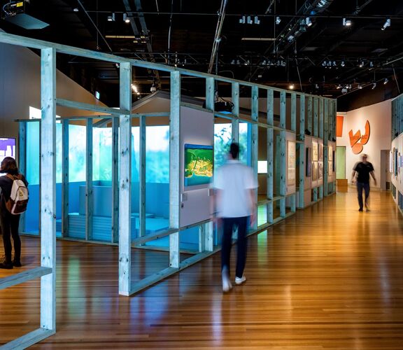 Three people exploring the Purpose Built exhibition.