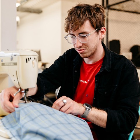 Young man sewing