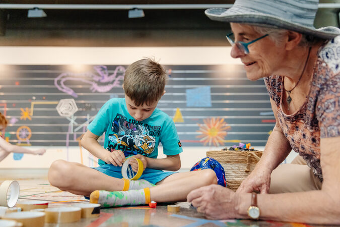 Boy sitting on floor crafting with tape